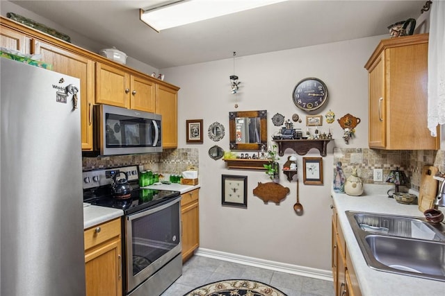 kitchen with sink, hanging light fixtures, light tile patterned floors, stainless steel appliances, and decorative backsplash