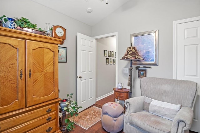 sitting room with lofted ceiling and dark wood-type flooring