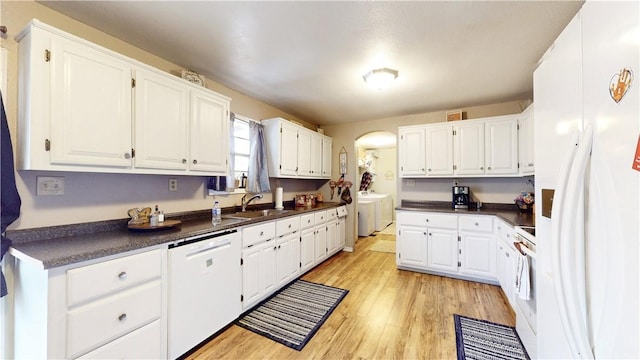 kitchen with sink, white appliances, light hardwood / wood-style flooring, white cabinetry, and separate washer and dryer