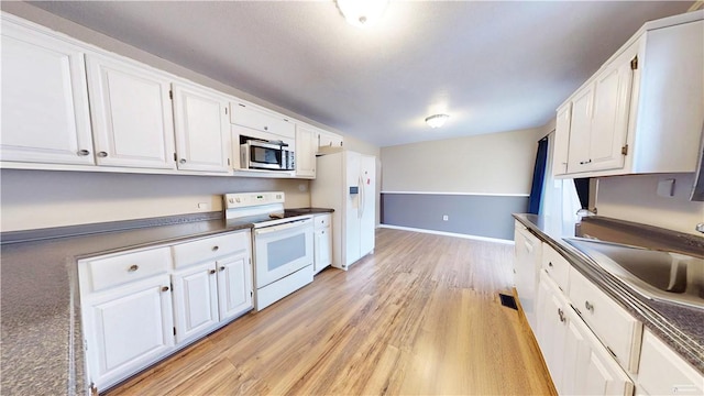 kitchen featuring sink, white appliances, white cabinets, and light wood-type flooring