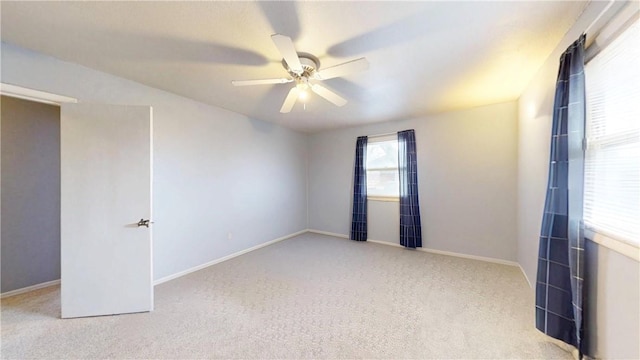 spare room featuring ceiling fan and light carpet