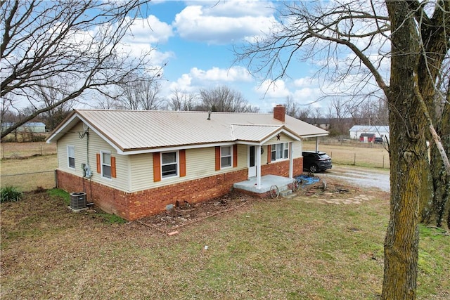 ranch-style home with cooling unit, a front yard, and a carport