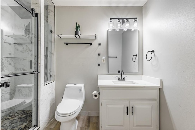 full bath featuring vanity, toilet, wood finished floors, and a marble finish shower