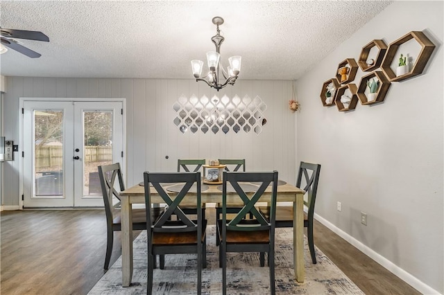 dining space featuring a textured ceiling, wood finished floors, french doors, baseboards, and a chandelier