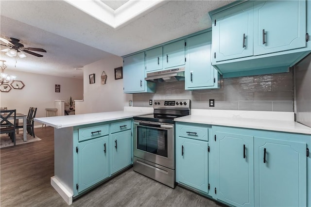 kitchen with electric range, under cabinet range hood, wood finished floors, a peninsula, and decorative backsplash