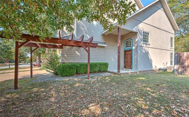 view of front of home featuring a pergola and a front lawn