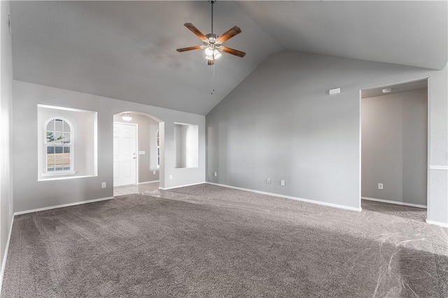 unfurnished living room featuring baseboards, arched walkways, carpet, and a ceiling fan