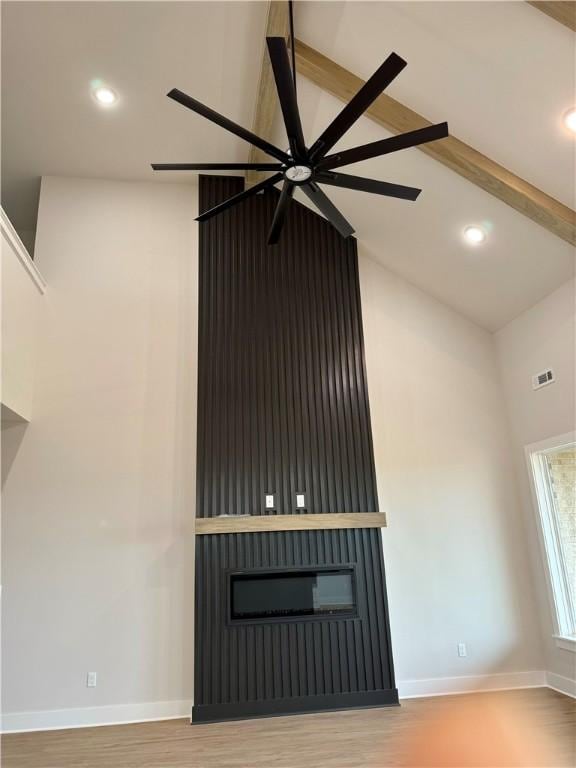 unfurnished living room featuring hardwood / wood-style flooring and lofted ceiling with beams