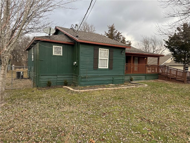 view of property exterior featuring central AC, a yard, and a wooden deck