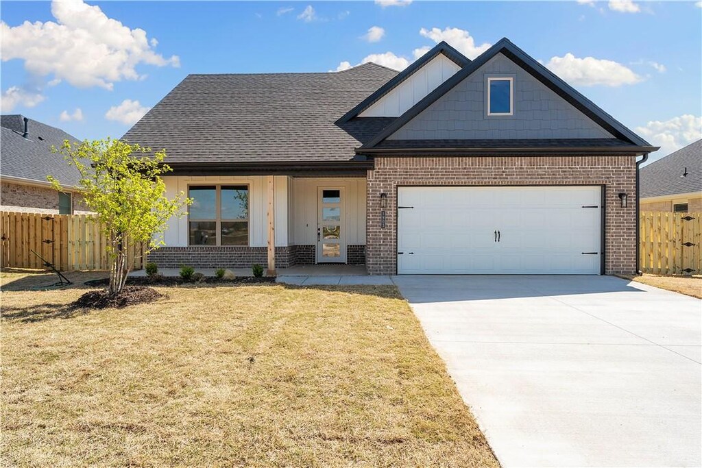 1903 Bugg St, Pea Ridge, AR 72751 - view of front of property featuring brick siding, a front yard, fence, and concrete driveway