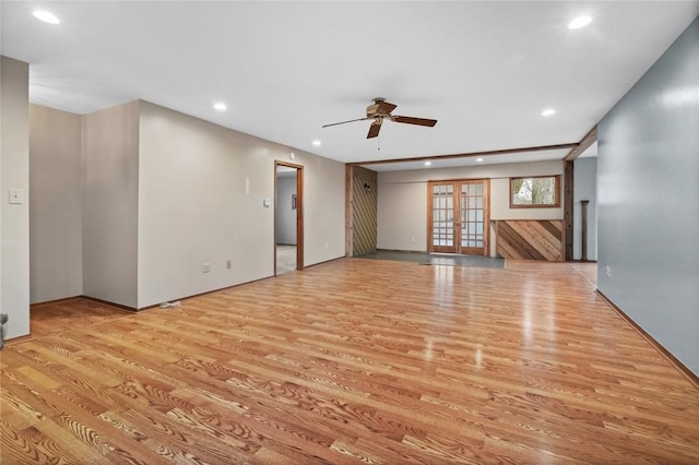 unfurnished living room with french doors, ceiling fan, and light wood-type flooring