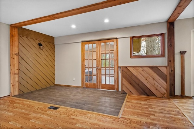 doorway featuring hardwood / wood-style flooring, beamed ceiling, french doors, and wood walls