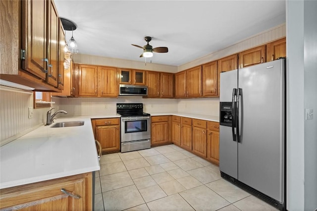 kitchen featuring sink, light tile patterned floors, ceiling fan, hanging light fixtures, and stainless steel appliances