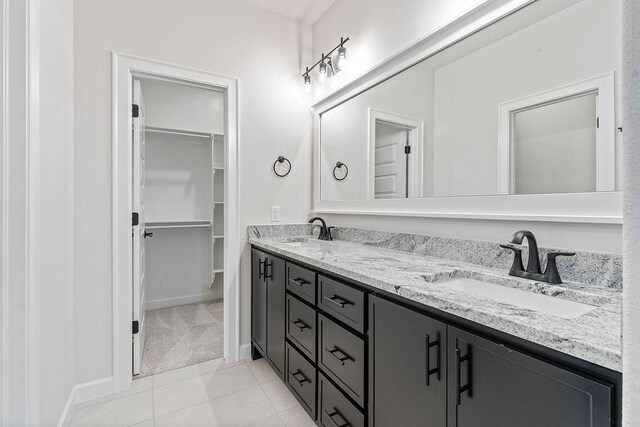 1815 Bugg St, Pea Ridge, AR 72751 - bathroom featuring double vanity, a walk in closet, tile patterned flooring, and baseboards