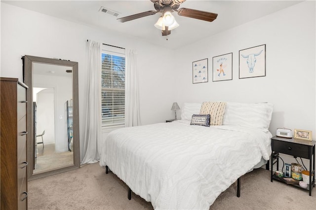 bedroom with ceiling fan and light carpet