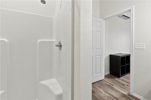 bathroom featuring walk in shower and hardwood / wood-style floors