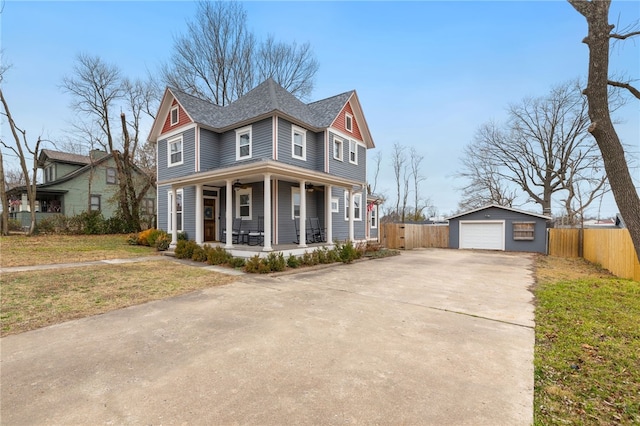 view of front facade featuring a garage, an outdoor structure, a front yard, and covered porch