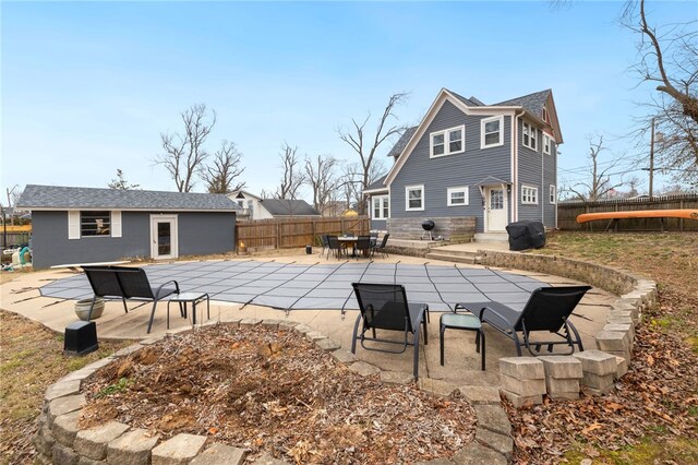 rear view of house featuring a patio and an outbuilding