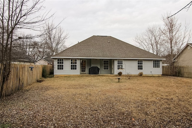 rear view of property with a yard