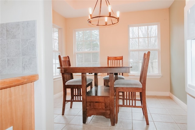 dining space featuring light tile patterned flooring, a healthy amount of sunlight, and a chandelier