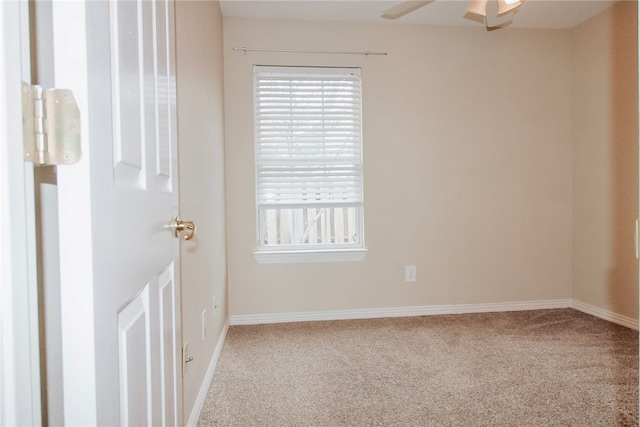 carpeted spare room with ceiling fan