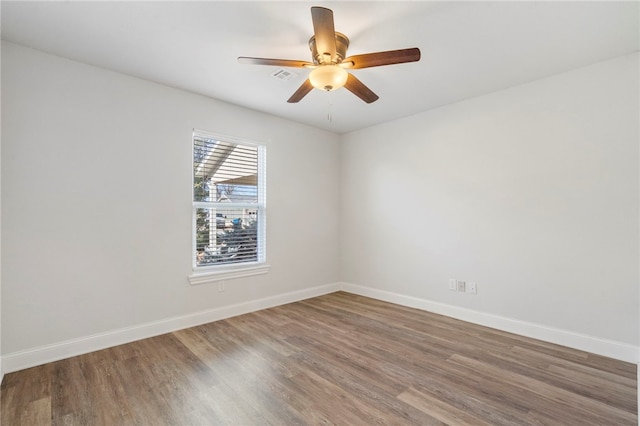 unfurnished room featuring a ceiling fan, visible vents, baseboards, and wood finished floors