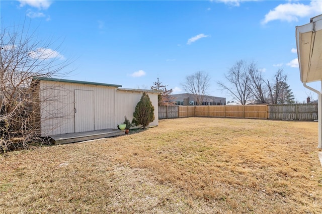 view of yard with an outbuilding, a shed, and a fenced backyard