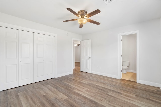 unfurnished bedroom featuring light wood-type flooring, a closet, and baseboards