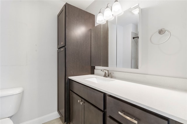 bathroom featuring vanity, toilet, and baseboards