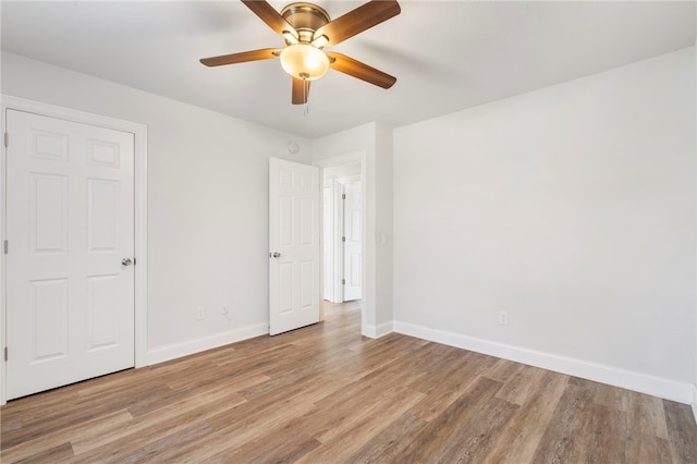 unfurnished bedroom with light wood-style flooring, baseboards, and ceiling fan