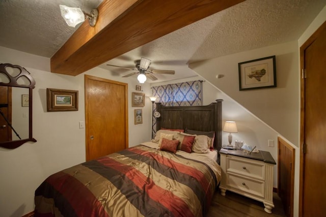 bedroom featuring dark hardwood / wood-style flooring, ceiling fan, beam ceiling, and a textured ceiling