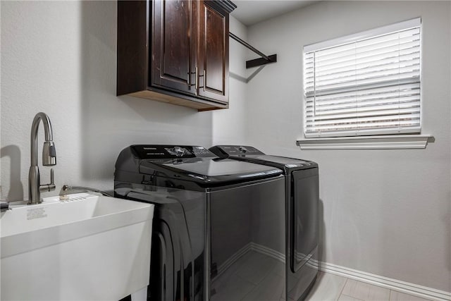 laundry room with cabinets, sink, and washer and clothes dryer