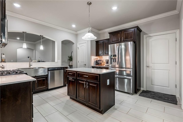 kitchen featuring pendant lighting, decorative backsplash, a center island, stainless steel appliances, and dark brown cabinets