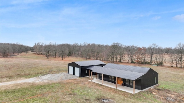 view of front of property featuring a garage, a rural view, and a front lawn