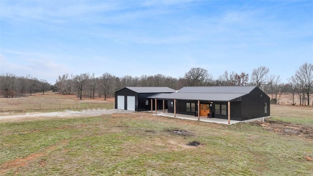 view of front facade with a rural view, a garage, and a front lawn