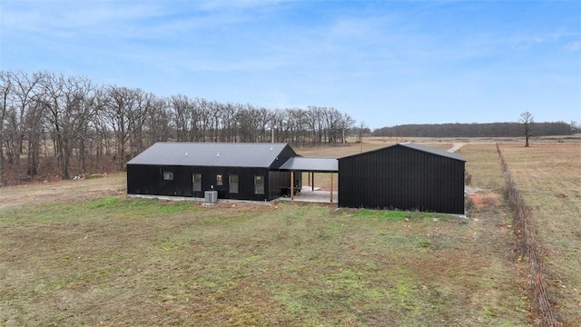 back of house with a carport, a yard, a rural view, and cooling unit