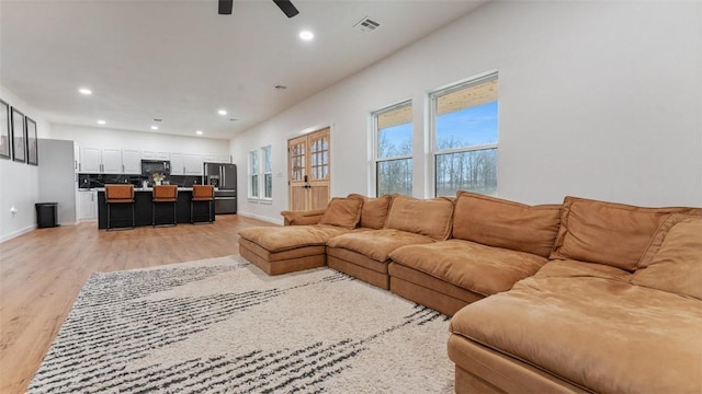 living room with ceiling fan and light hardwood / wood-style floors