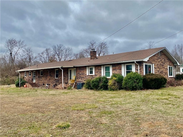 view of front of house with central AC unit and a front yard