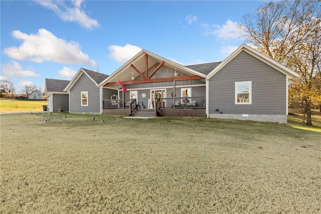 rear view of house with a lawn and a porch