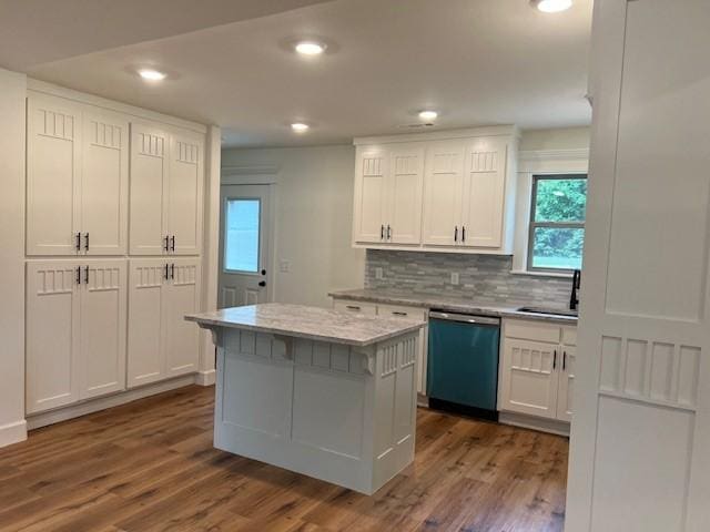 kitchen featuring white cabinetry, sink, hardwood / wood-style flooring, a center island, and stainless steel dishwasher