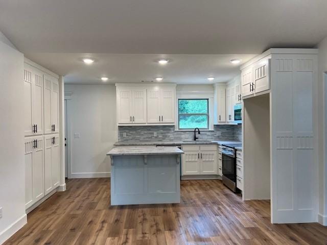 kitchen featuring white cabinetry, stainless steel electric stove, dark wood-type flooring, and backsplash