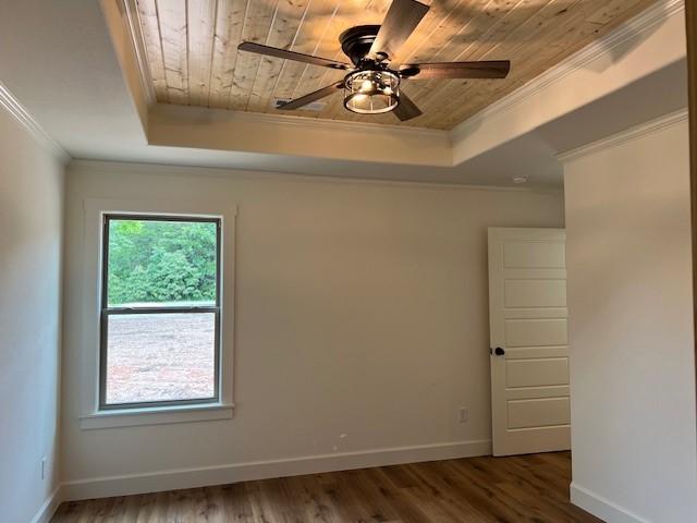 unfurnished room featuring a raised ceiling, crown molding, hardwood / wood-style floors, and wooden ceiling