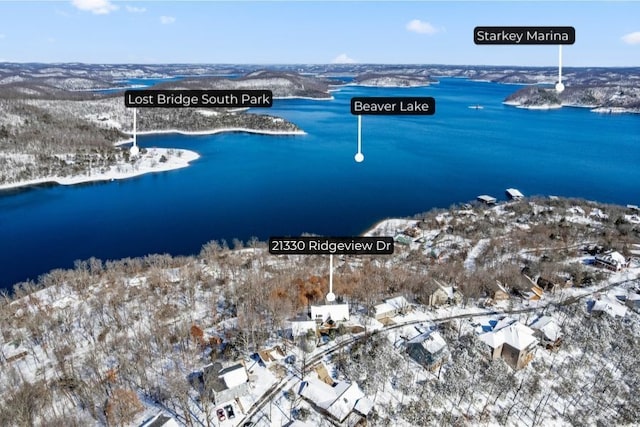 snowy aerial view featuring a water view