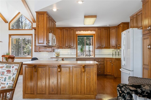 21330 Ridgeview Dr, Garfield, AR 72732 - kitchen with white appliances, a sink, a peninsula, brown cabinets, and tasteful backsplash