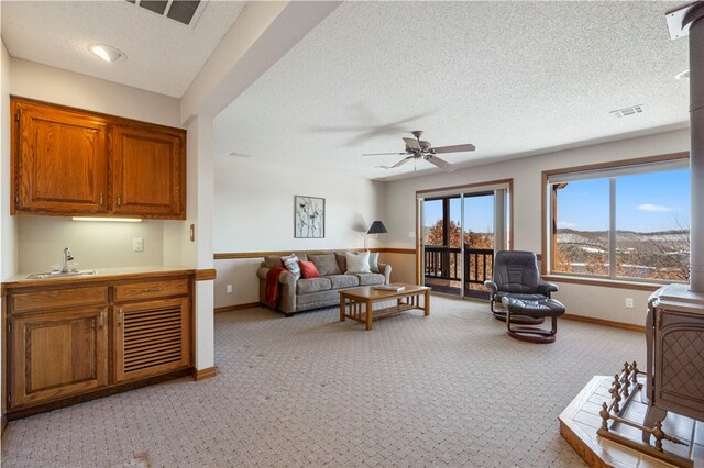 21330 Ridgeview Dr, Garfield, AR 72732 - living room featuring light colored carpet, baseboards, a ceiling fan, and a textured ceiling
