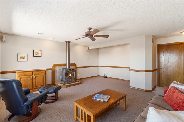 21330 Ridgeview Dr, Garfield, AR 72732 - carpeted living room featuring a wood stove, ceiling fan, a textured ceiling, and baseboards