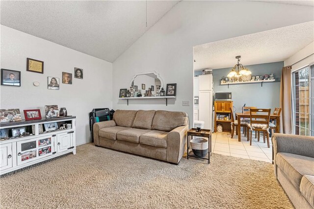 carpeted living room with high vaulted ceiling, an inviting chandelier, and a textured ceiling