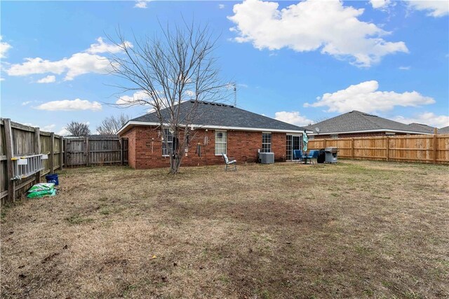 back of house featuring central AC and a yard