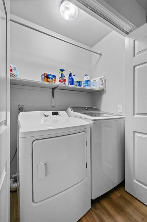 clothes washing area featuring dark wood-type flooring and washer and dryer