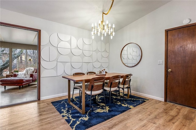 dining area with a chandelier, baseboards, and wood finished floors